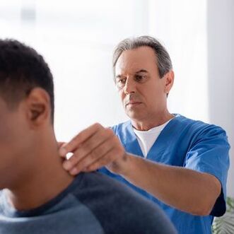 Zdravnik opravi diagnostični pregled bolnika z bolečino v vratu